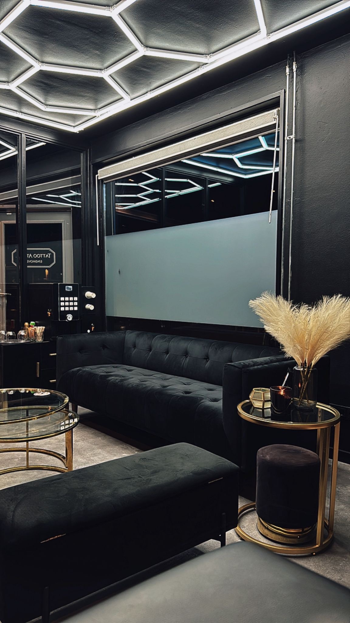 Creative Cult Tattoo studio interior — donkere wanden, gouden accenten, fluwelen meubilair